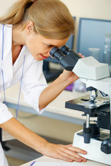 Woman working with a microscope.