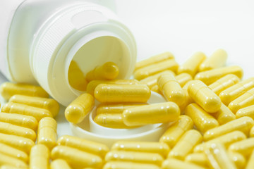 Yellow Drug Capsules spilled from container