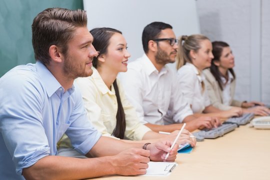 Business team sitting in a line listening during a meeting