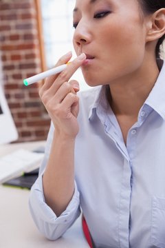Casual businesswoman smoking an electronic cigarette