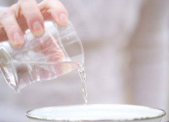 .Pouring water from a glass for making mulled wine.