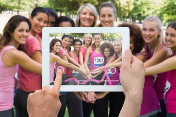 Composite image of hand holding tablet pc