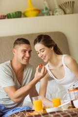 Obraz na płótnie Canvas Cute couple having breakfast in bed
