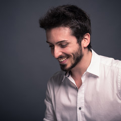 Fototapeta premium Smiling man close up portrait against dark background.