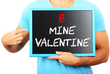 Man holding blackboard in hands and pointing the word B MINE VAL