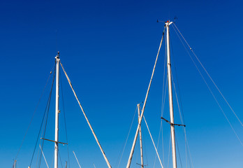 Obraz premium Detail shot of sailing boat poles (mainmasts) in marina.