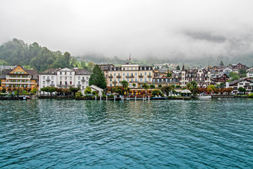 Fototapeta na wymiar Swiss town on Lucerne lake in fog, Switzerland