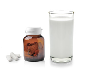 pill and glass of milk isolated on white background
