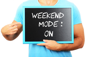 Man holding blackboard in hands and pointing the word WEEKEND MO