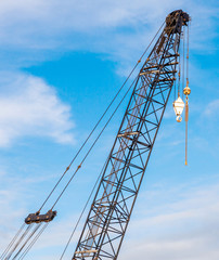 The hoisting crane with pulley and hook in construction site aga