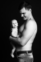 Infant baby boy on his father's arms