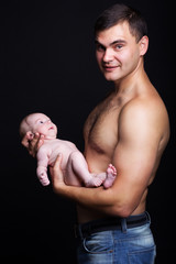 Infant baby boy on his father's arms