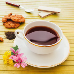 Cup of english tea with assorted chocolate cookies