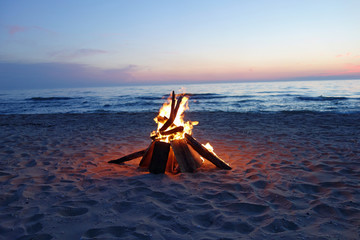 Naklejka premium Campfire at dusk by the lake