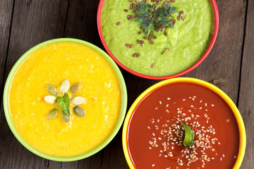 Three fresh soups on a wooden table