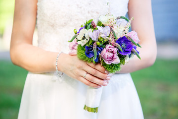 Obraz na płótnie Canvas Beautiful bridal bouquet on a woman hands