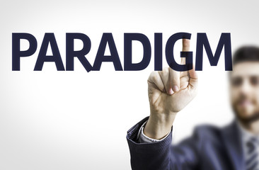 Business man pointing to transparent board with text: Paradigm
