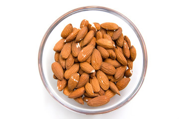 Almonds in glass bowl on white background from above