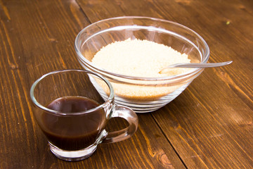 Coffee and bowl with brown sugar on wooden table