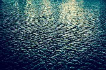 Wet cobblestone street at night