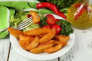 Homemade fried potato on plate on wooden background