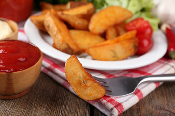 Homemade fried potato on plate on wooden background