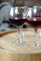 Glasses of wine in cellar with old barrels