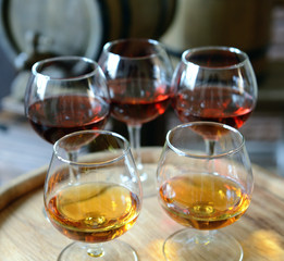 Glasses of brandy in cellar with old barrels