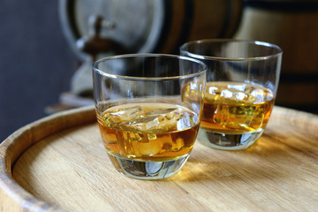 Glasses of brandy in cellar with old barrels