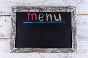 Inscription menu on chalkboard on table close-up