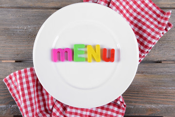 Inscription menu on plate on table close-up