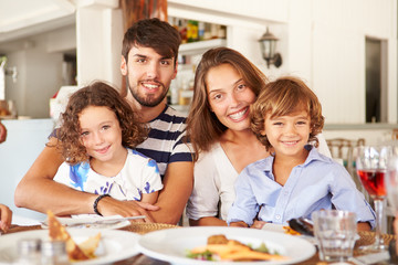 Portrait Of Family Enjoying Meal In Restaurant