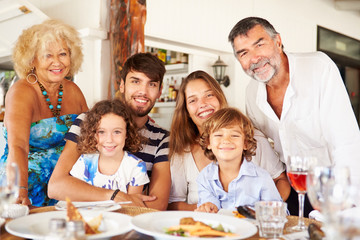 Multi Generation Family Enjoying Meal In Restaurant