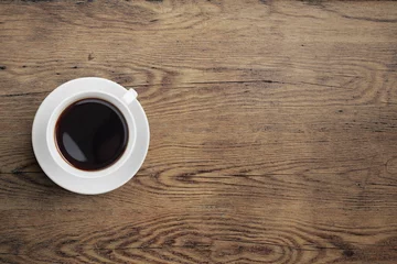  Black coffee cup on old wooden table top view © Andrey Kuzmin