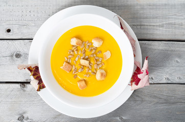 Pumpkin soup against wooden background