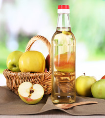 Apple cider vinegar in glass bottle and ripe fresh apples,
