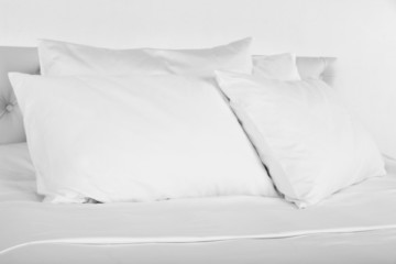 Fototapeta na wymiar White pillows on bed in room