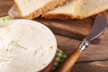 Fresh homemade butter in bowl and sliced bread,