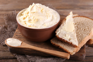 Fototapeta na wymiar Fresh homemade butter in bowl and sliced bread,