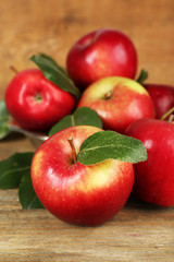 Ripe apples in bowl on wooden background