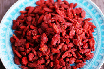 Goji berries on blue plate closeup