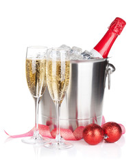 Champagne bottle in ice bucket, two glasses and christmas decor