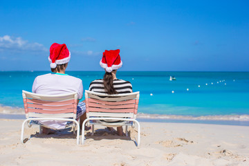 Happy couple wearing Santa hat at caribbean beach