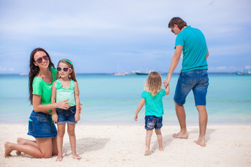 Family of four walking by the sea and enjoy beach vacation