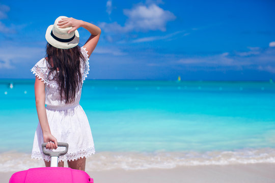Young beautiful girl with luggage during beach vacation