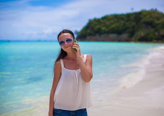 Closeup young beautiful woman at beach talking on her phone