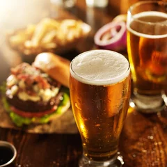 Rolgordijnen Bier bier en hamburgers op houten tafel