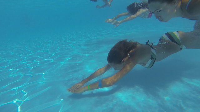 Beautiful slender girls swim underwater