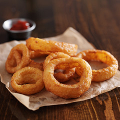 crispy onion rings with ketchup on parchment paper