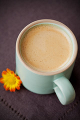 Cup of coffee with bright autumn flowers
